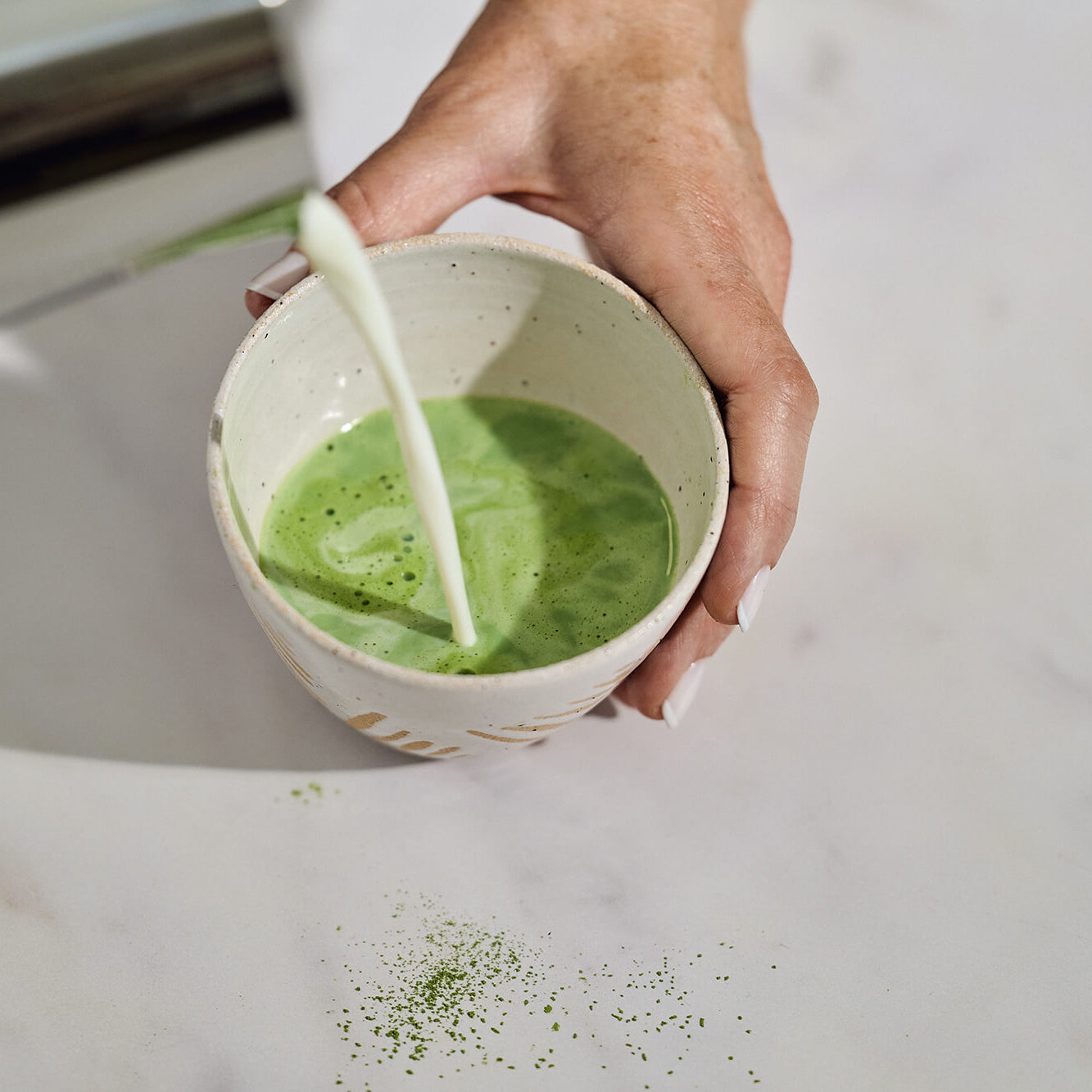 adding milk to matcha tea