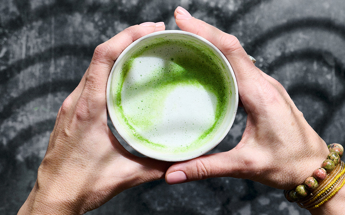 Mug of matcha tea held by both hands