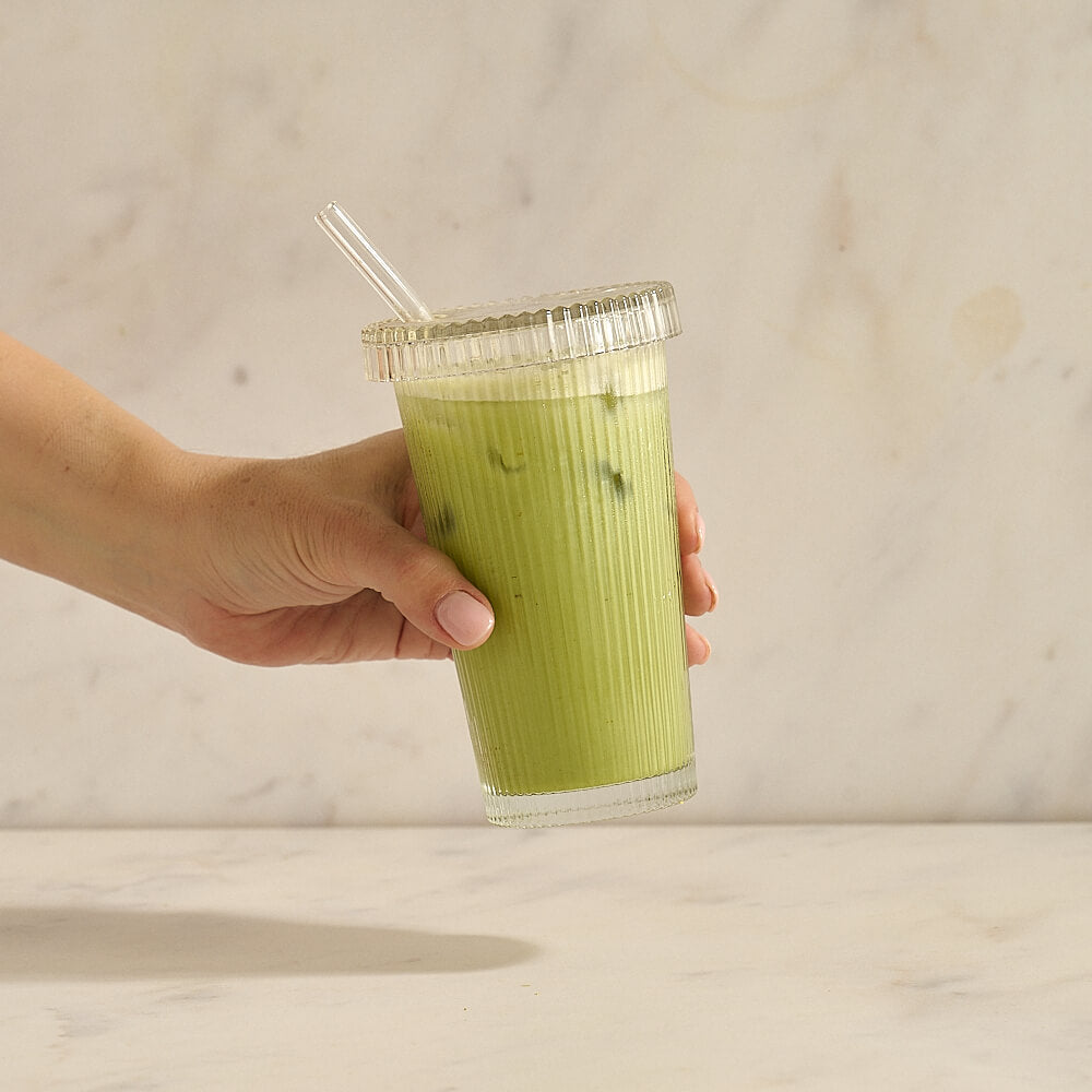 Iced matcha latte in glass with straw