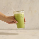 Iced matcha latte in glass with straw