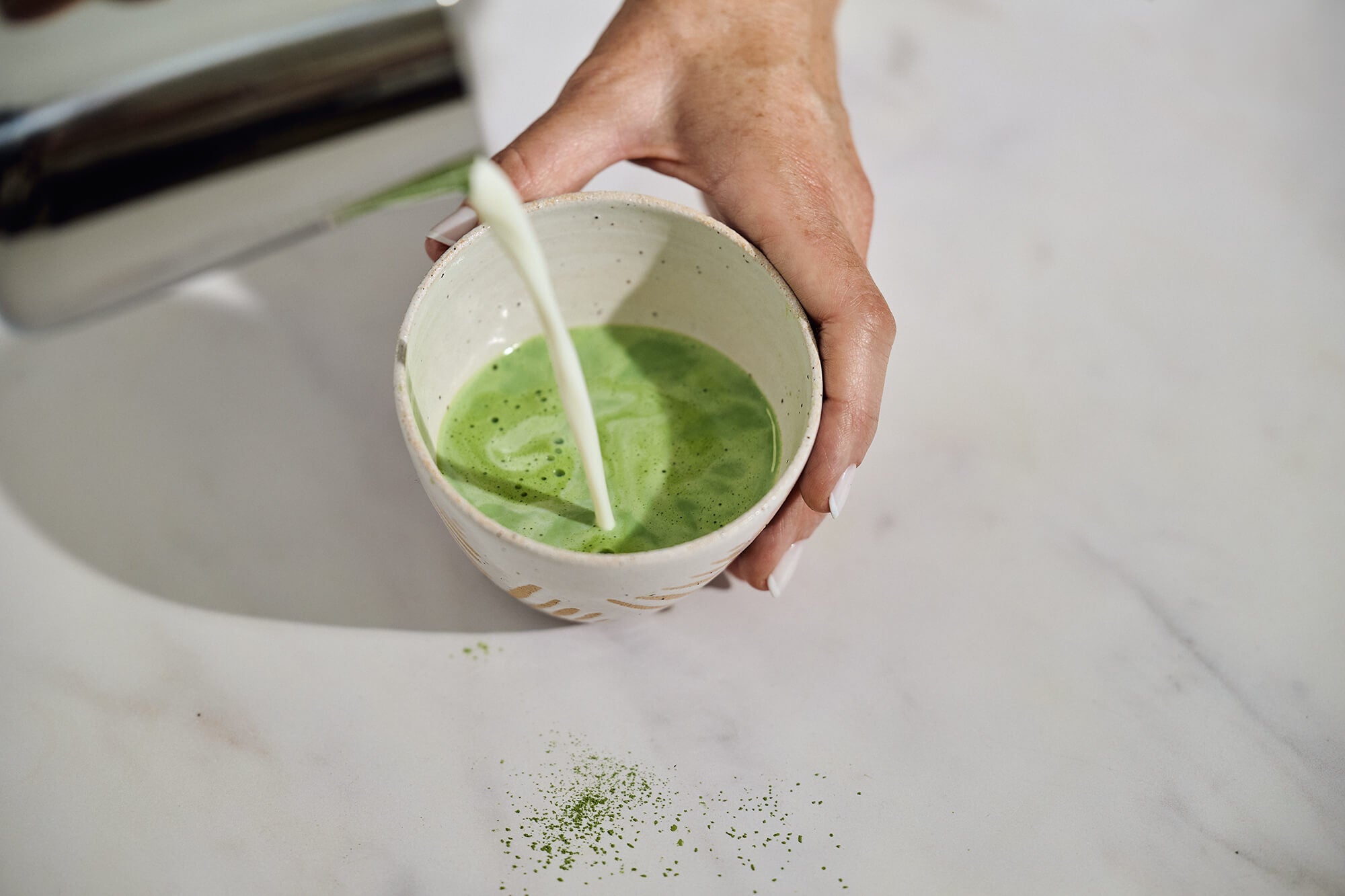 adding milk to matcha tea