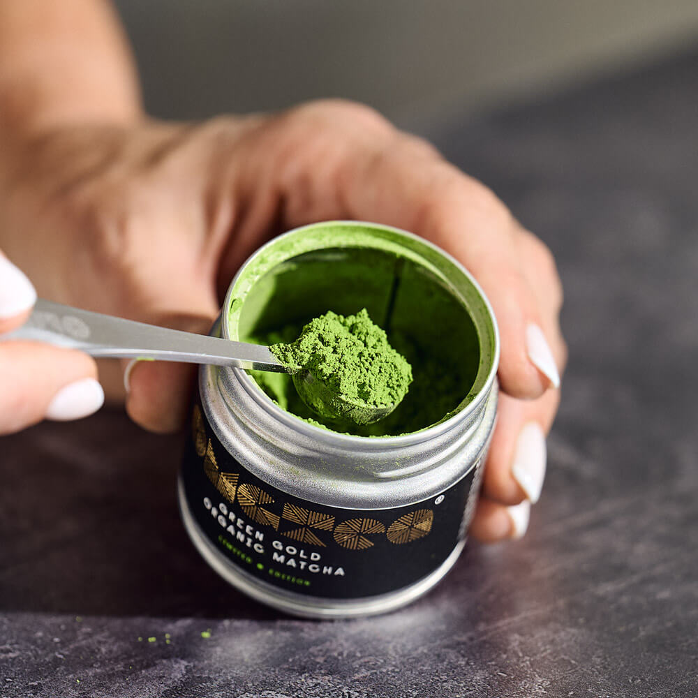 open matcha tea tin with spoon full of match tea